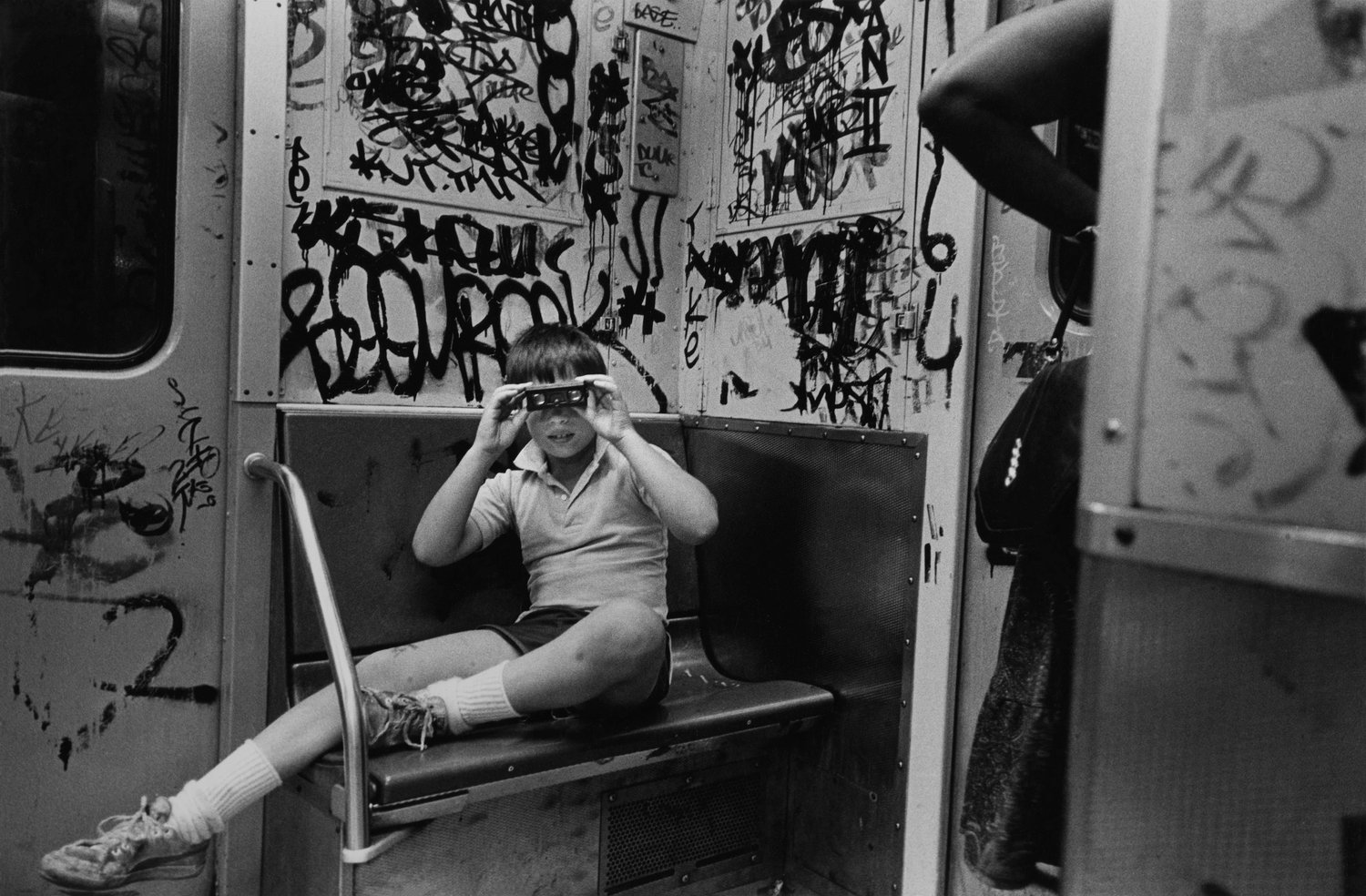 Black & white street photography by Richard Sandler, boy with binocolaurs on NYC subway