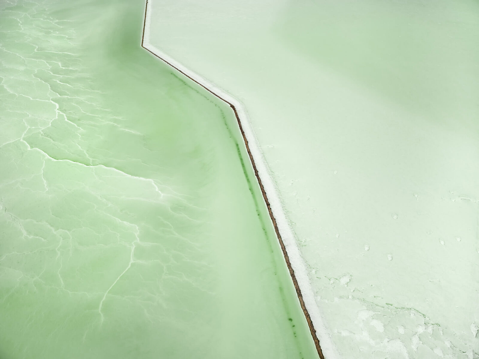 Aerial landscape photography by Tom Hegen of pale green salt pools. From the book Salt Works.