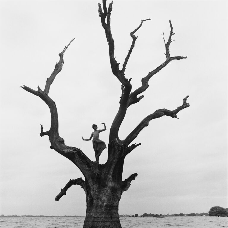 Black & white portrait photography by Monica Denevan, woman dancing on a tree in Burma, Myanmar