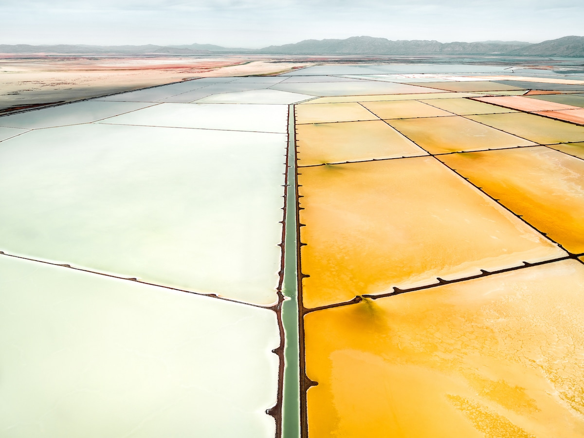 Aerial landscape photography by Tom Hegen of yellow and blue salt pools. From the book Salt Works.