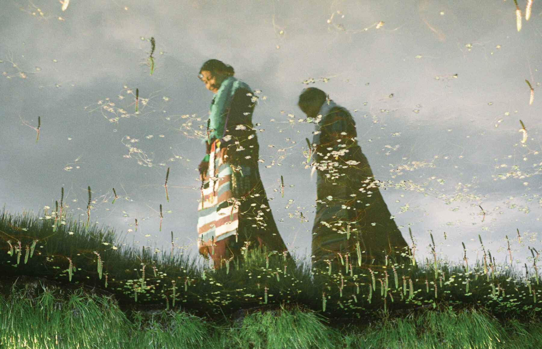 Color photo of two women in water reflexion by Kin Coedel