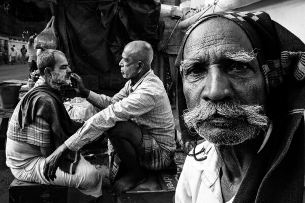 black and white street photo of men shaving in kolkota, india, by Arpit Mehrotra