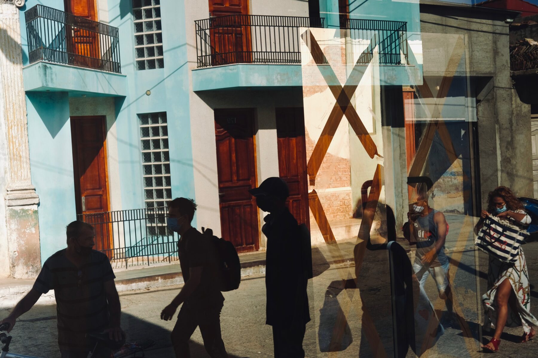 color street photo of people reflxion in Trinidad, Cuba by Johannes Maechtel