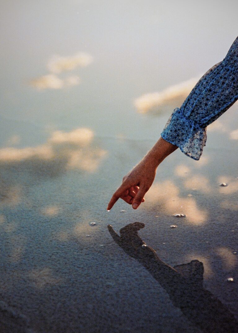 Color film photography by Jakob Lilja-Ruiz. Hand in water, reflections of the sky