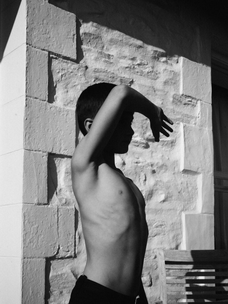 Black & White portrait photography by Phil Sharp, boy covering his face with his arm