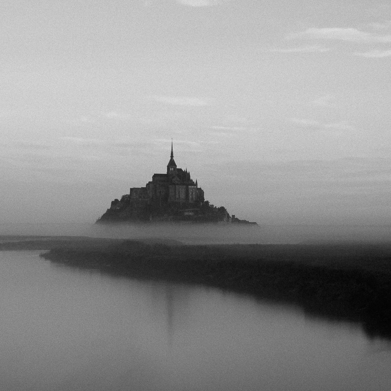 Black and white landscape photography by Adrian Vila. Town on a hill-shaped island.