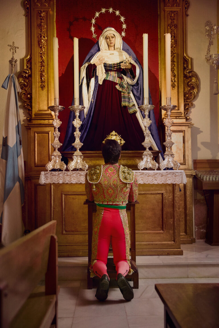 Photo of a young bullfighter praying at an altar by Owen Harvey