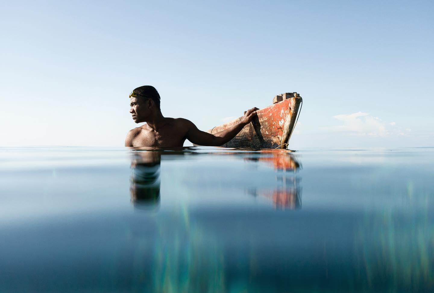 Travel photography by Jody Macdonald. Man in the water with a small boat