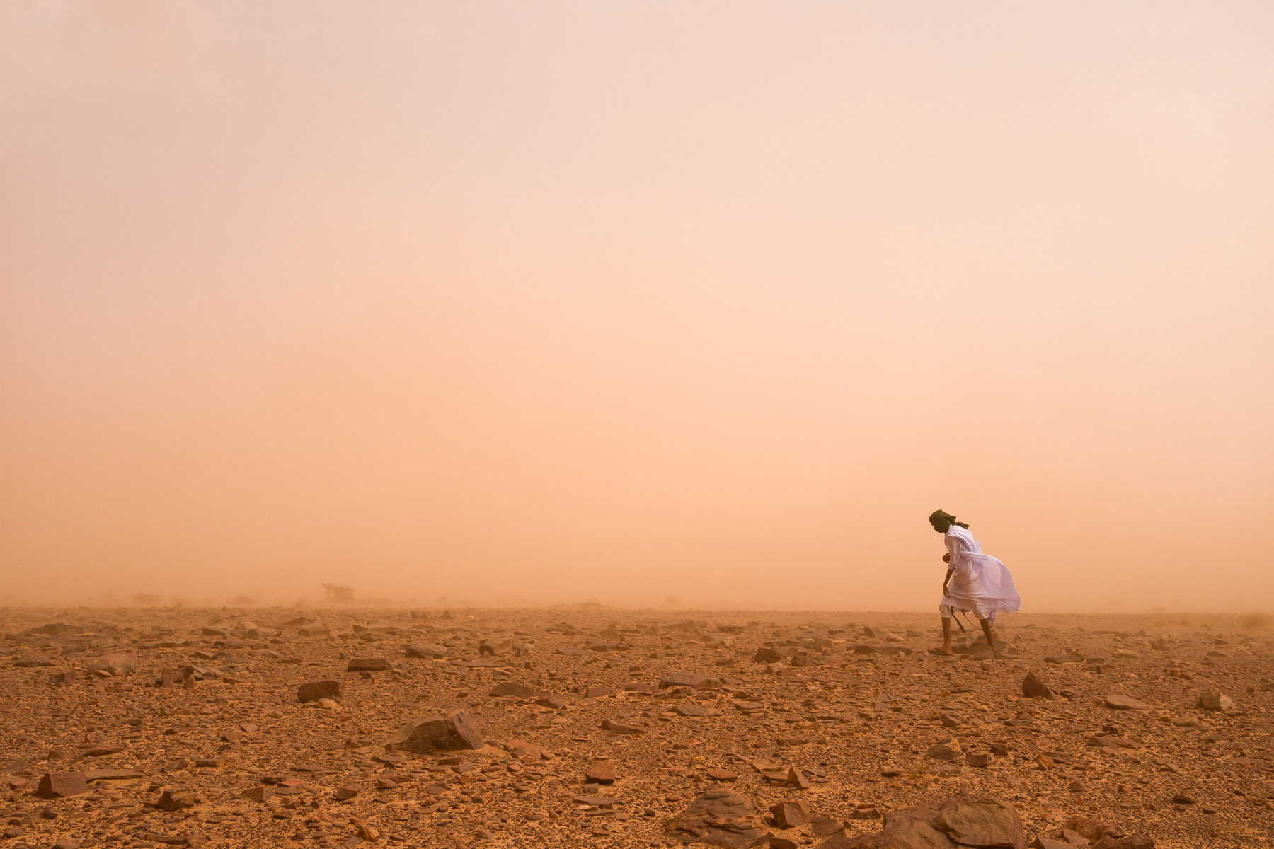 Photo of a man walking through the desert by Jody Macdonald