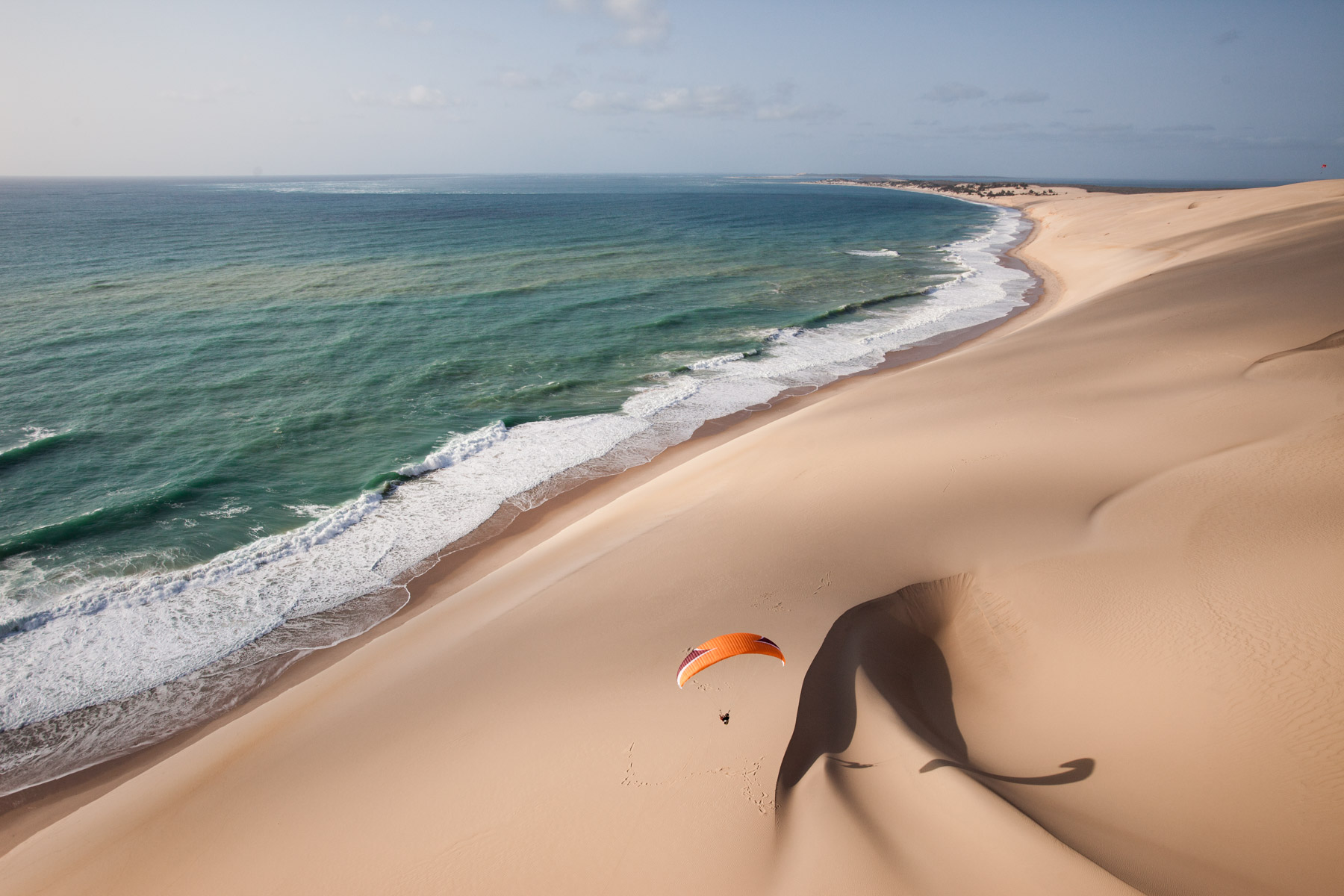 Travel photography by Jody Macdonald. Paraglider on sand dunes and ocean, Mozambique