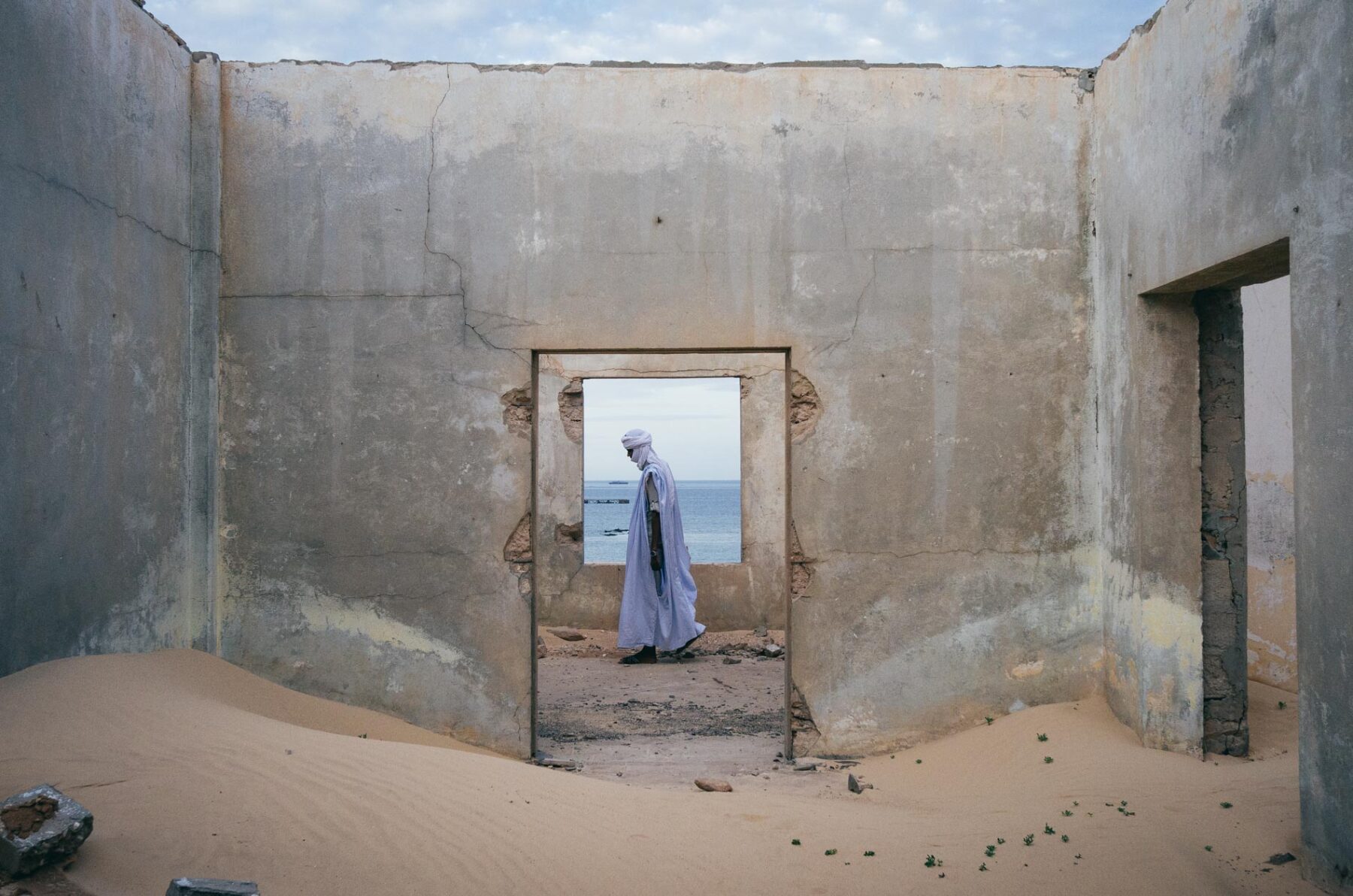 Travel photography by Jody Macdonald. A man walking through an abandoned building in the Sahara Desert by Jody Macdonald