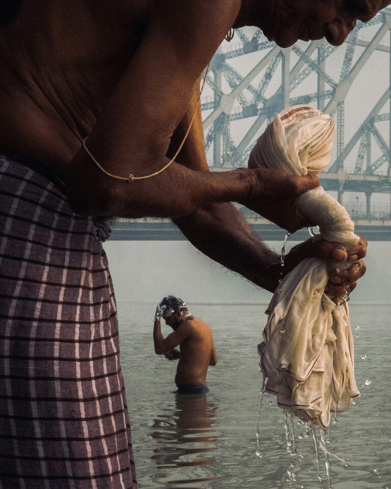 color travel photo of men bathing in river in Kolkata, India by Billy Dinh