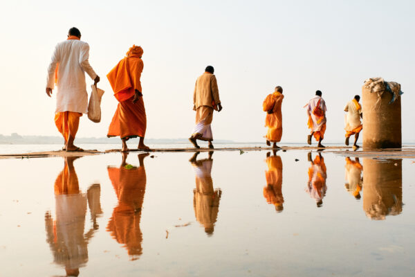 Color travel photography of pilgrims walking in Varanasi, India by Eduardo Ortiz