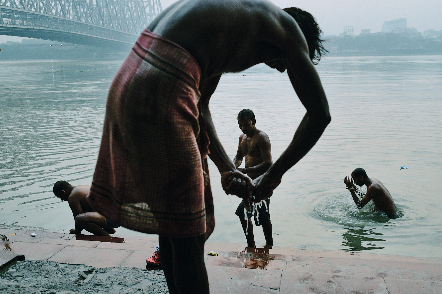 Street photography by Eduardo Ortiz. Men bathing in the ganges in Kolkata, India