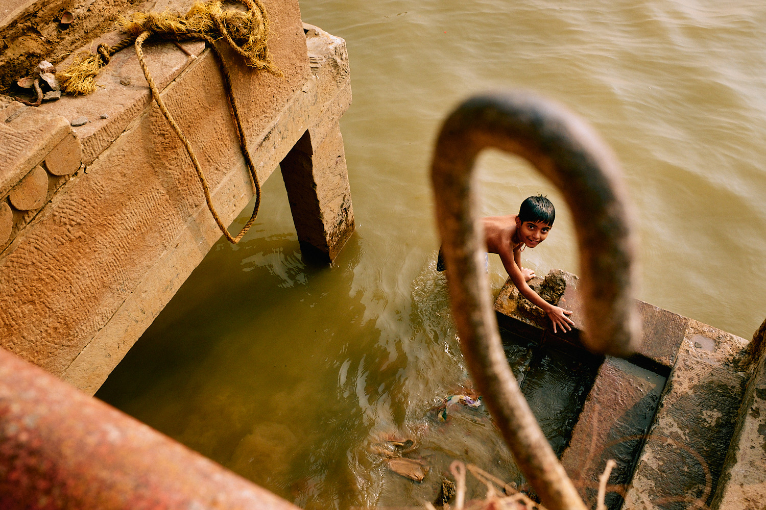 Street photography by Eduardo Ortiz, boy playing in a river in India