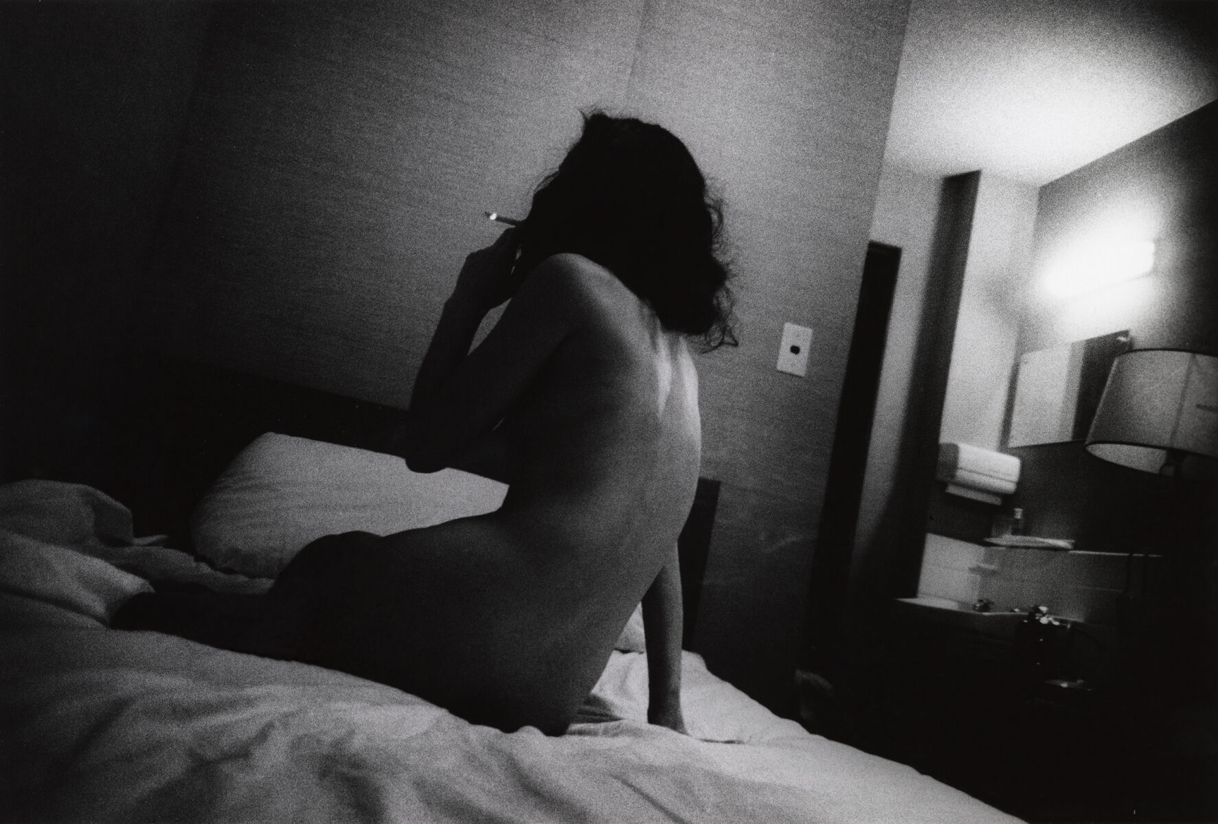 Black & white photo of a woman smoking by Daido Moriyama