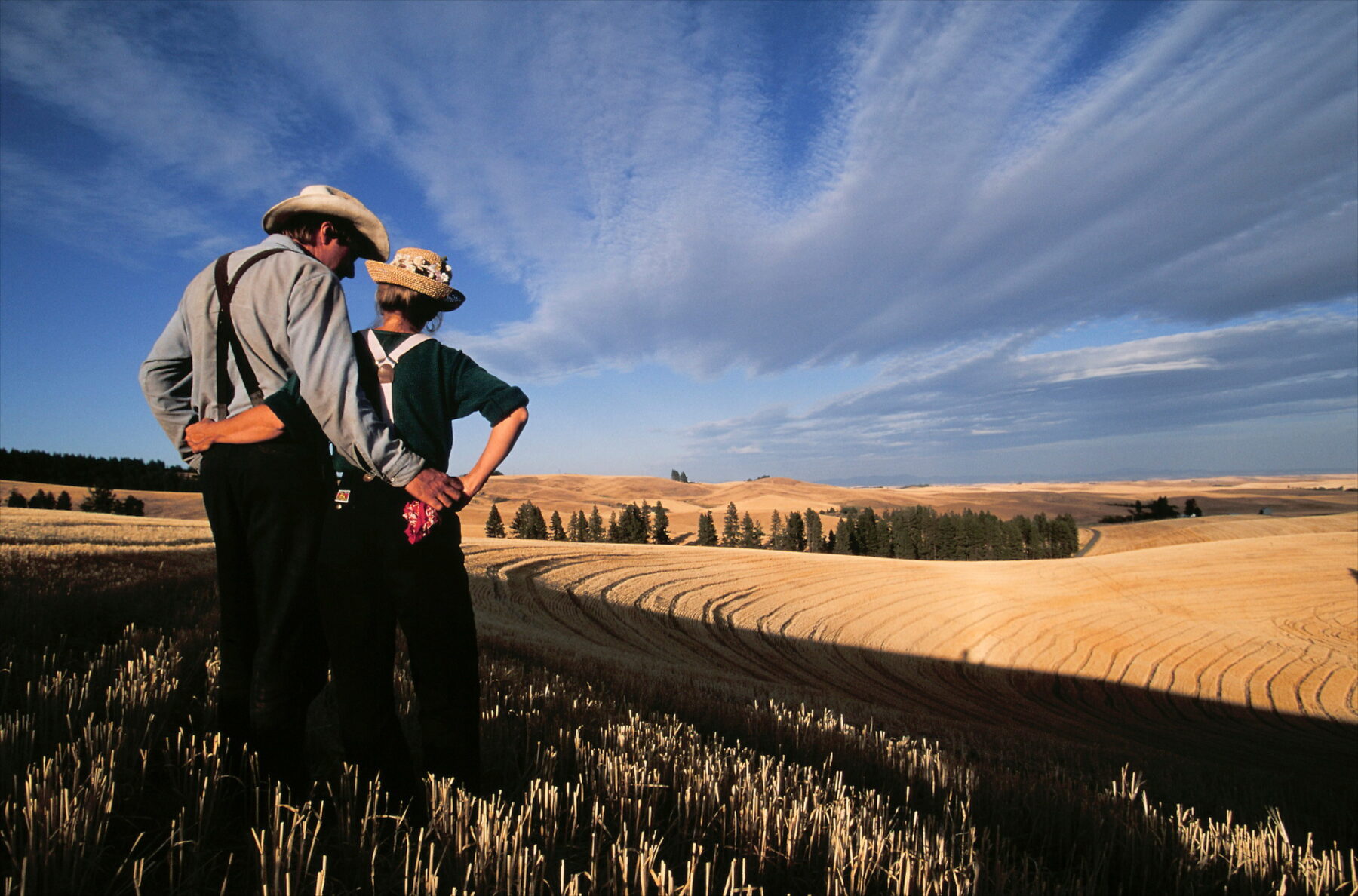 Photography by Jim Richardson. Farm couple in their wheat filed late in the afternoon in the Palouse of Washington. USA