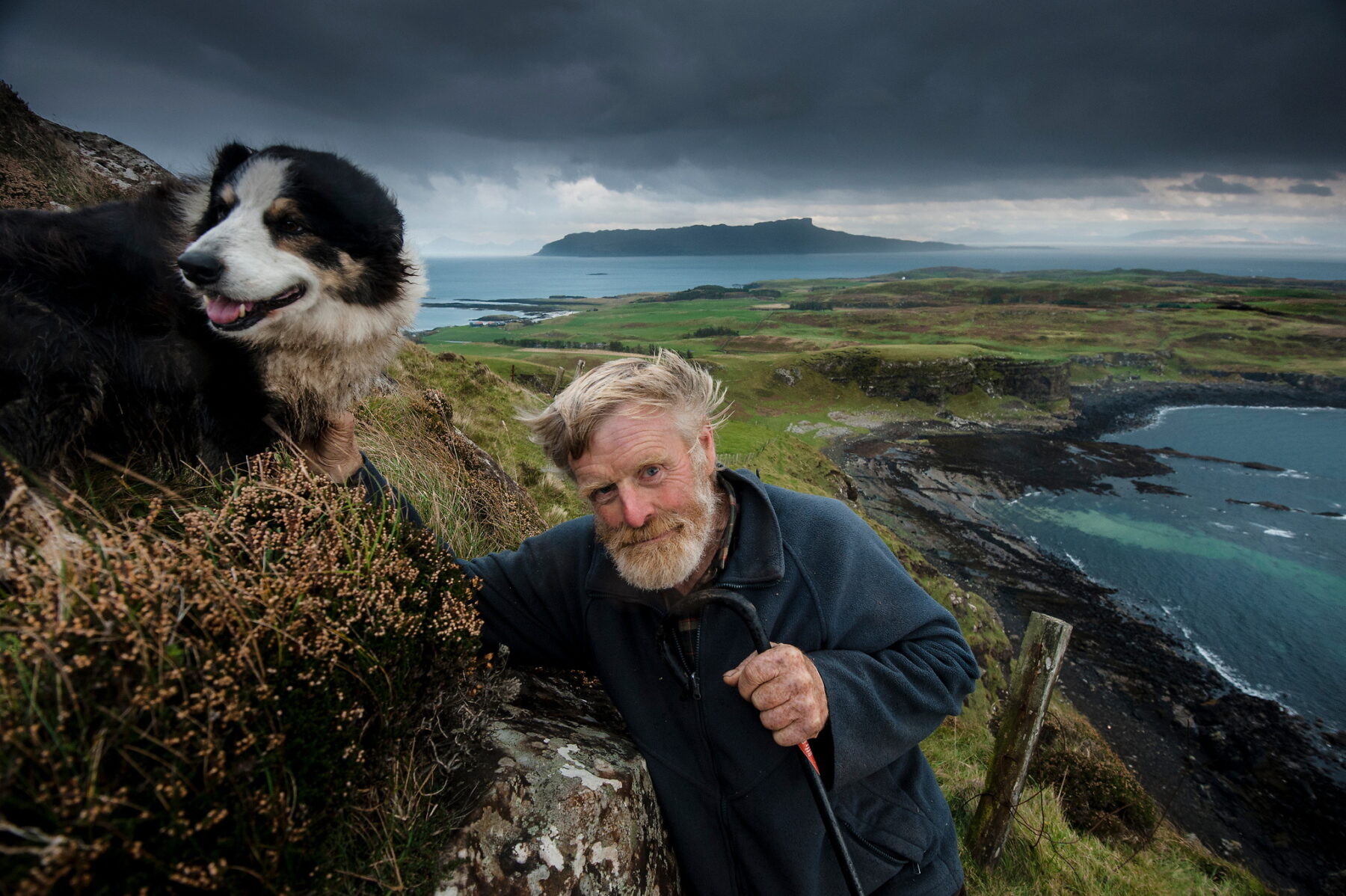 Photography by Jim Richardson. Man and a dog in Scotland, with mountains and coast in the background.