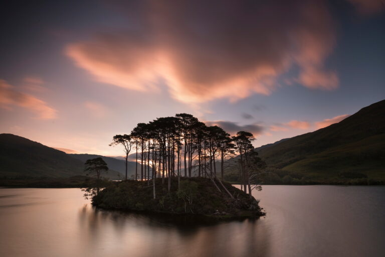 Landscape photography by Jim Richardson. A loch and a small island in the center with trees photographed at sunset.