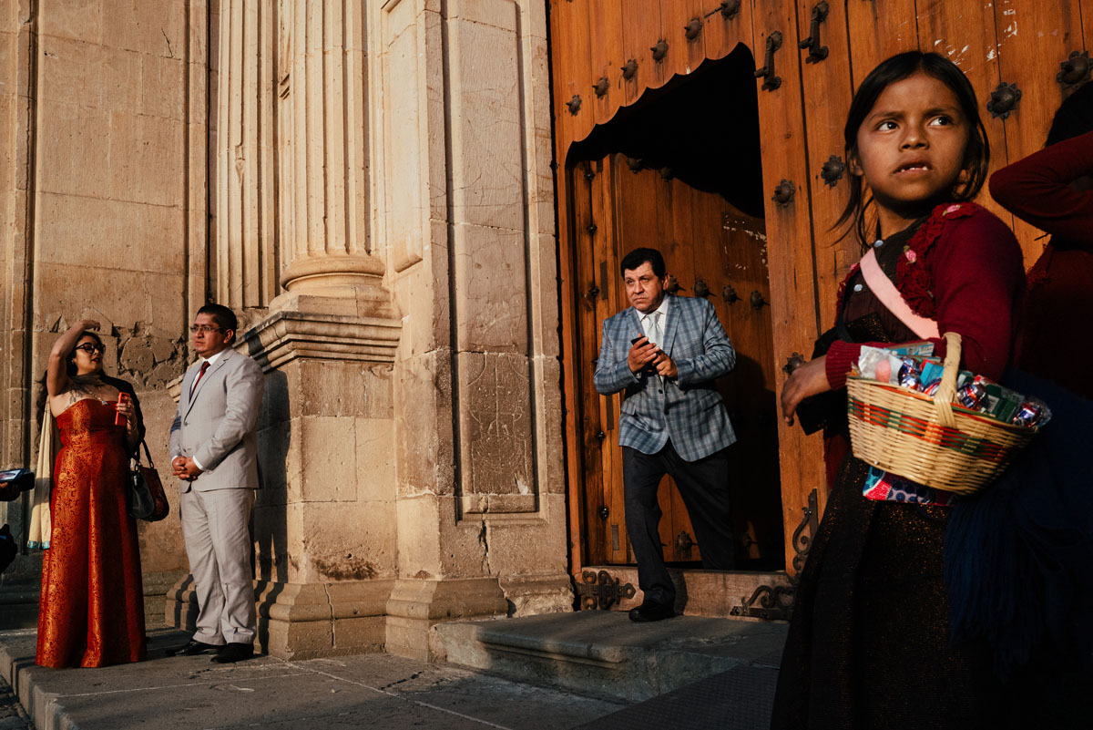 color street photo of people and young girl outside a church in Oaxaca, Mexico by Jonathan Jasberg