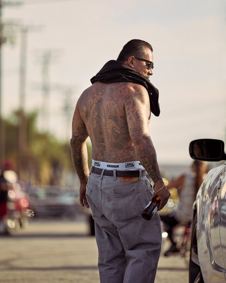 Documentary photography by Owen Harvey. A man approachs a car window down supply Av, Commerce, LA, California. From the project Ground Clearance LA