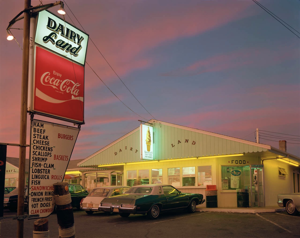 Photo of a sunset over an ice cream shop with cars in front of it by Joel Meyerowitz