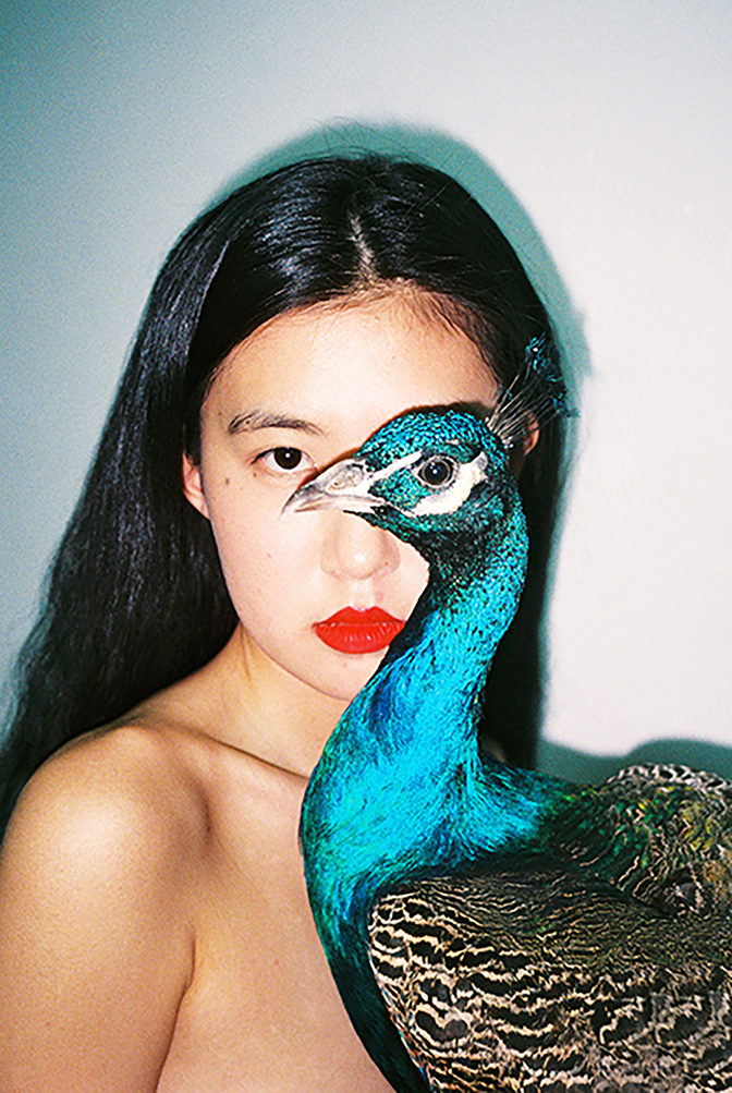 Photo of a woman and a peacock by Ren Hang