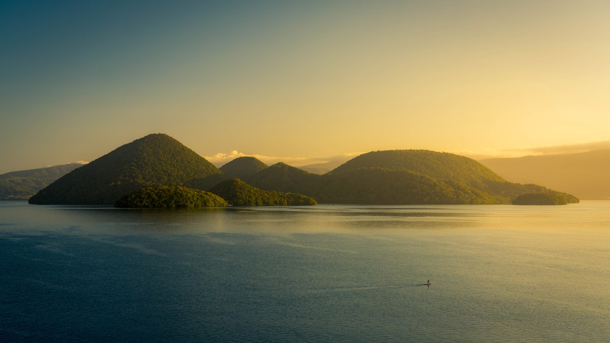 color landscape photo of island of lake Toya in japan by Song Wei Yin