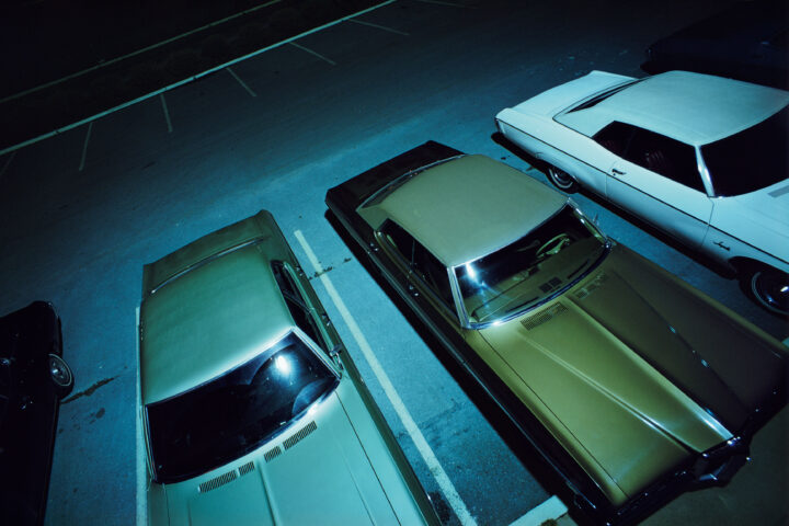 Color photography by William Eggleston. Cars at night.