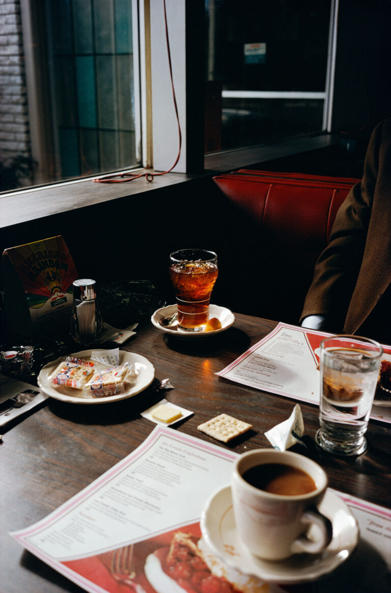 Color photography by William Eggleston. Cups and glasses on a restaurant table.