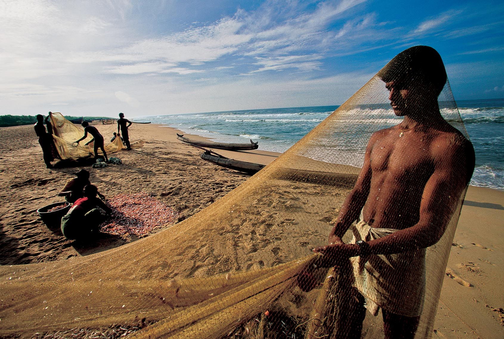 Photography by Michael Yamashita. Fishermen on the beach in India.