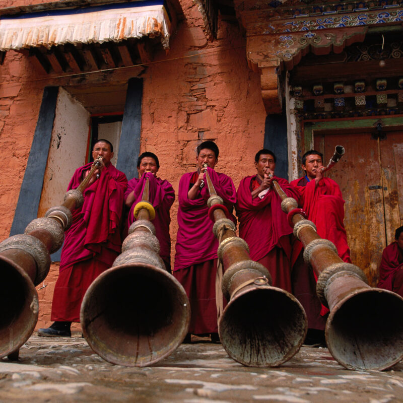 Photo of monks blowing large horns by Michael Yamashita