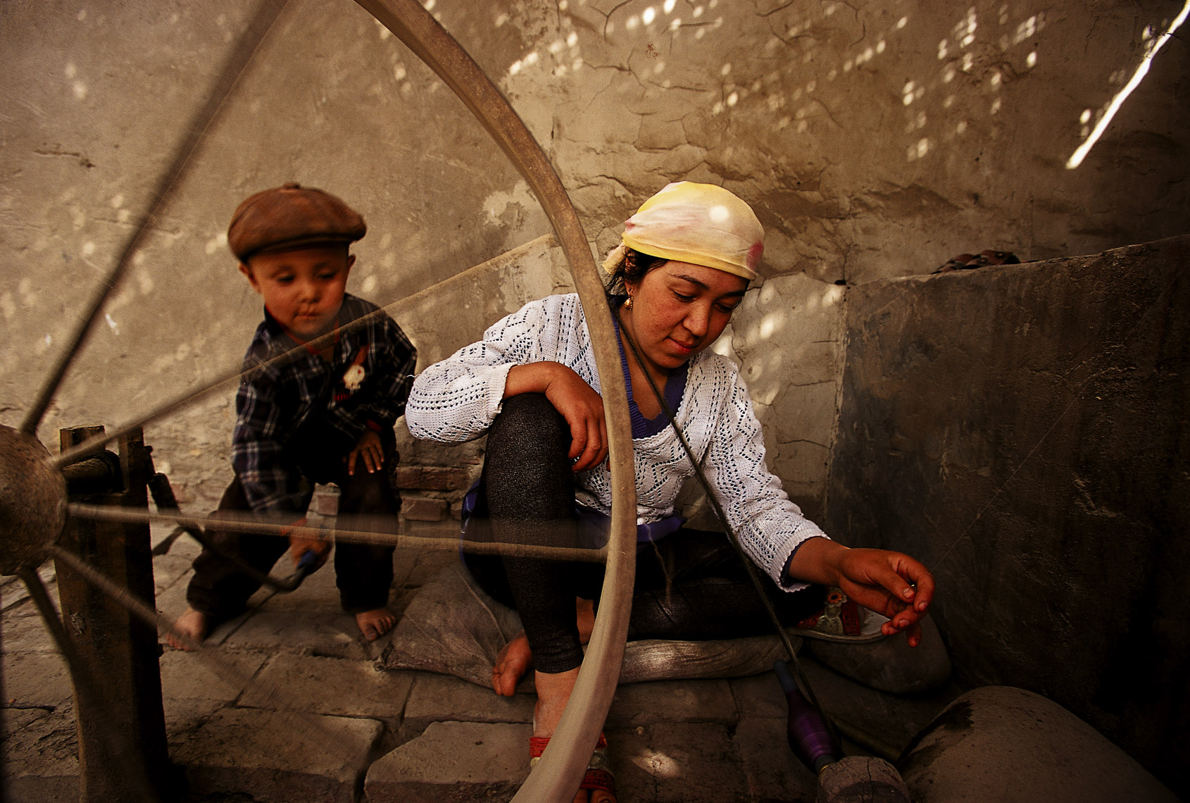 Photography by Michael Yamashita. Children spinning silk in Xinjiang, China