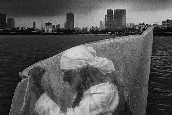 black and white photo of man under rain in Mumbai, India by Swarat Ghosh