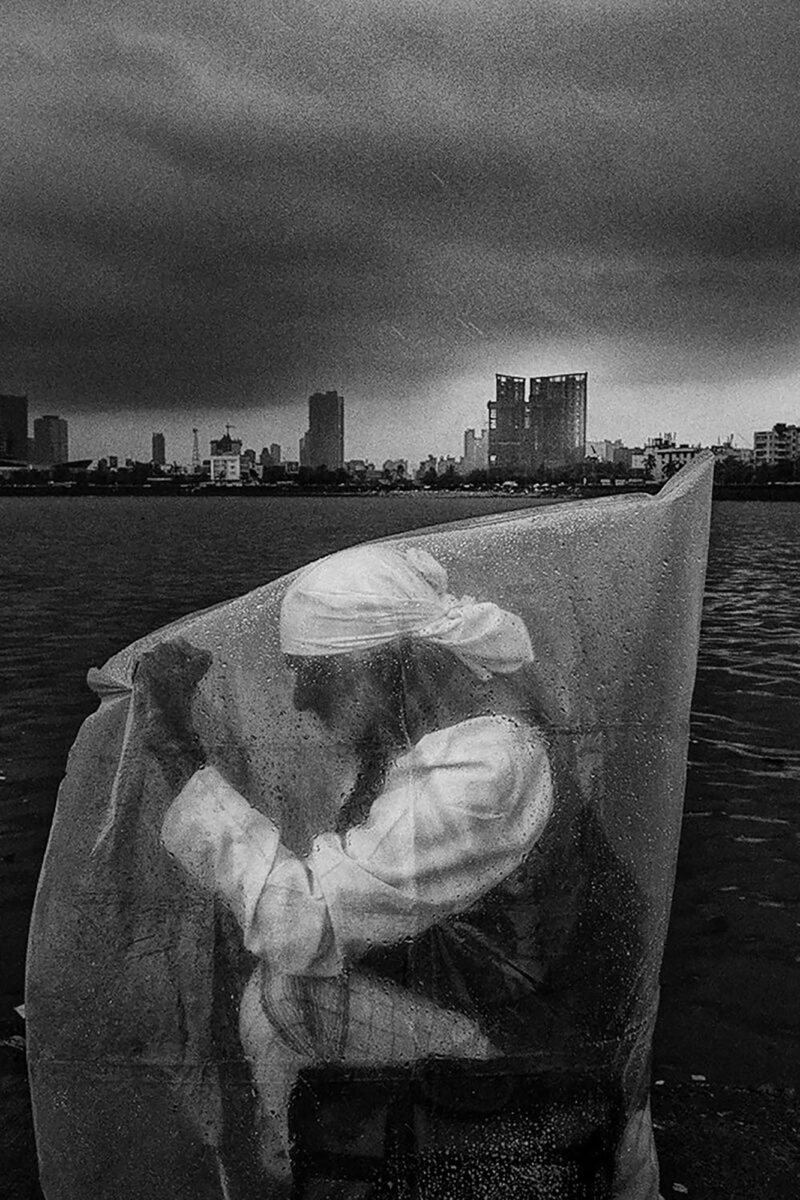 black and white photo of man under rain in Mumbai, India by Swarat Ghosh