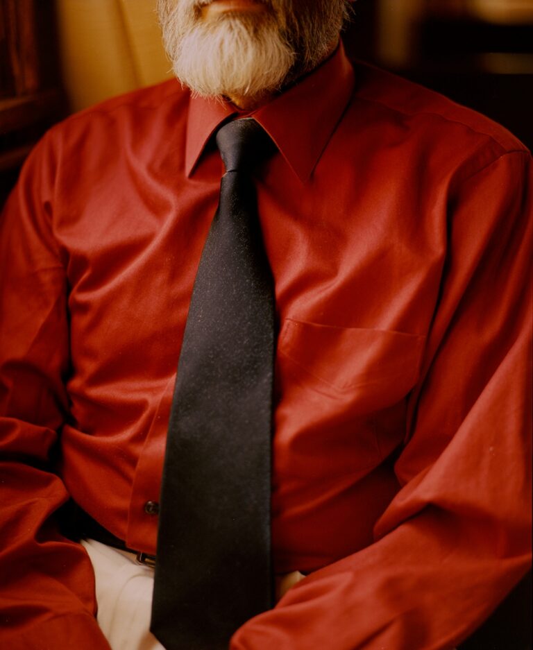 Color documentary photography by Mikel Bastida. From the book "Anarene". Man in red shirt with black tie