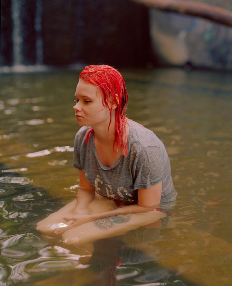 Color portrait photography by Mikel Bastida. Girl with bright red hair in water.