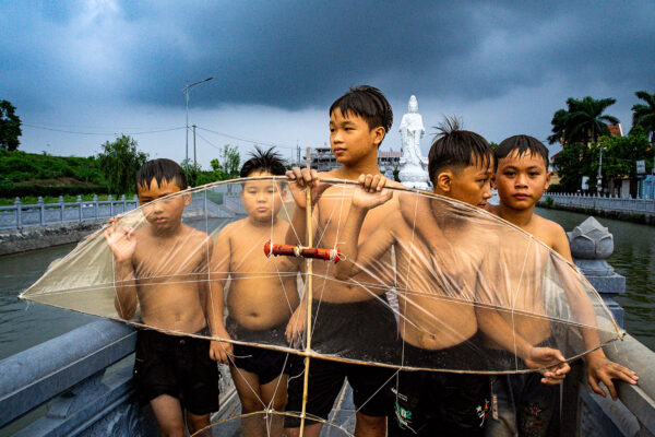 color photo of boys with flute kite in Hanoi, Vietnam by Phong Nguyen