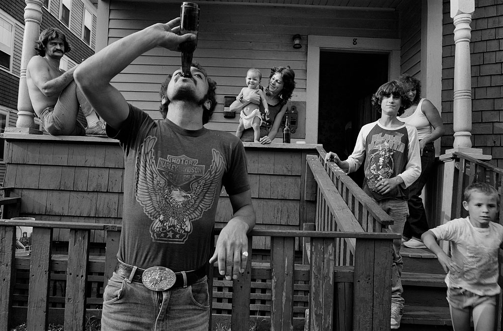 Black & white photo by Sage Sohier. People having drinks outside a house, 1983