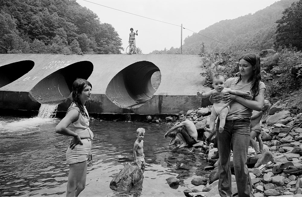 B&W photo by Sage Sohier. Family playing in river, usa 1982