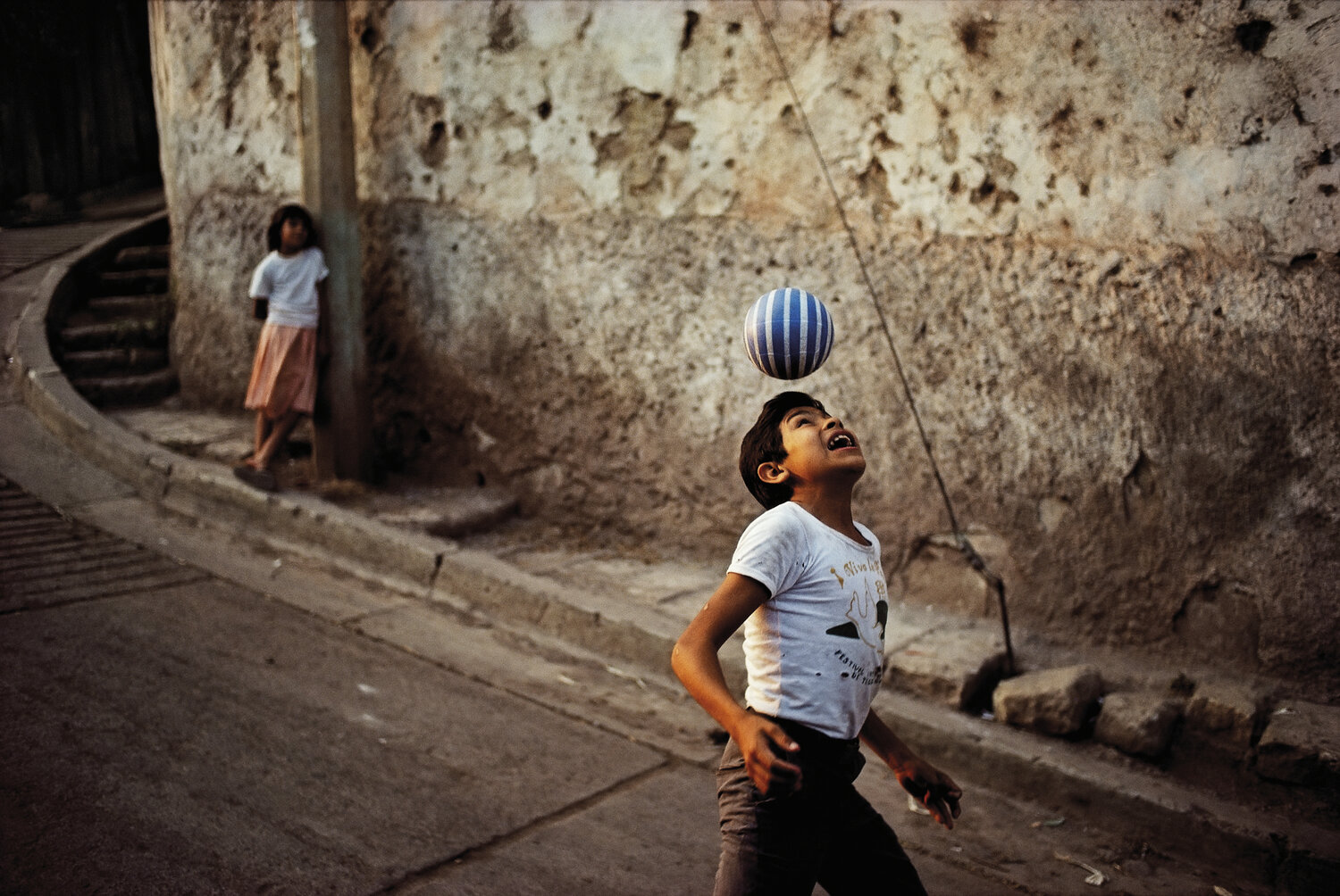 color street photo of kid playing with ball by David Alan Harvey