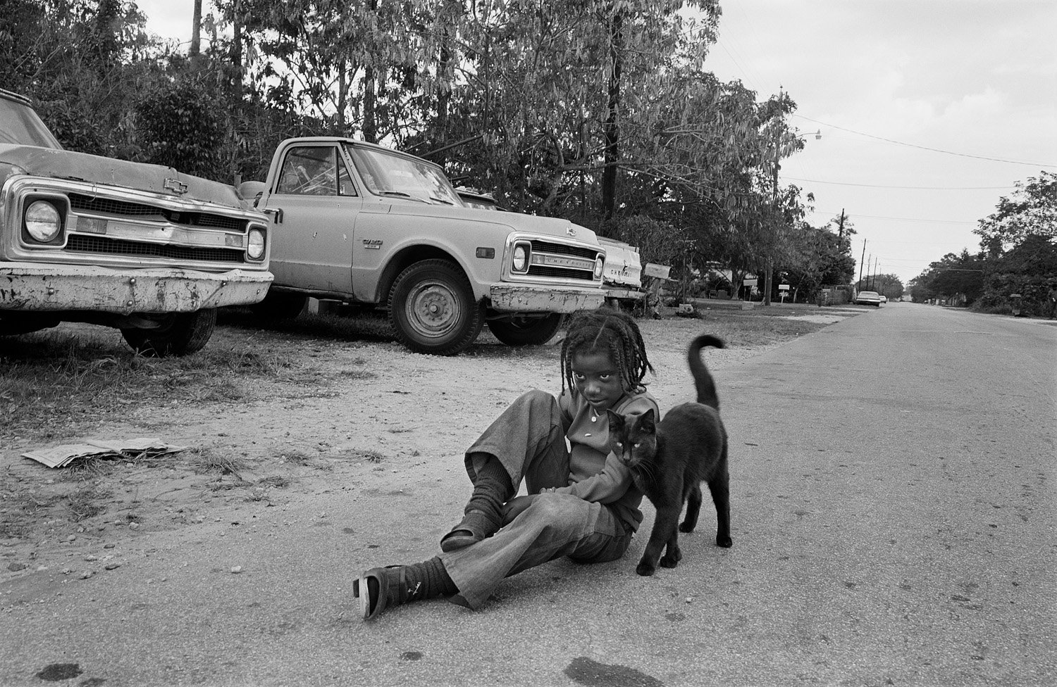 Black & white photo by Sage Sohier. Young boy and a cat in Florida. 1981